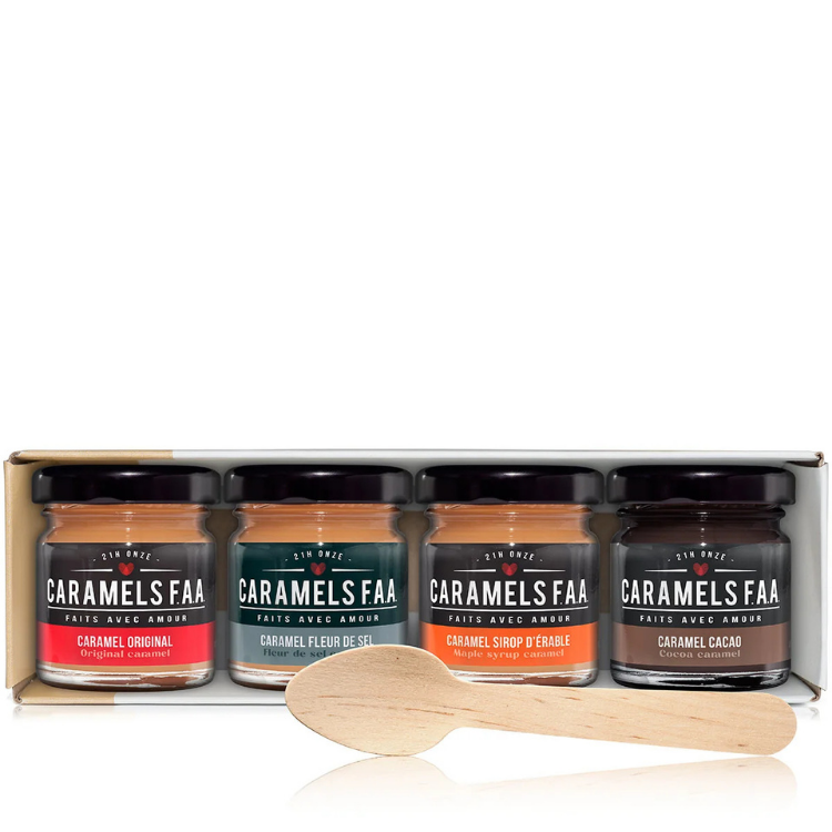 Un coffret blanc contenant 4 pots sur lesquels il est écrit Caramels FAA et des saveur avec une cuillère en bois avec un arrière plan blanc.