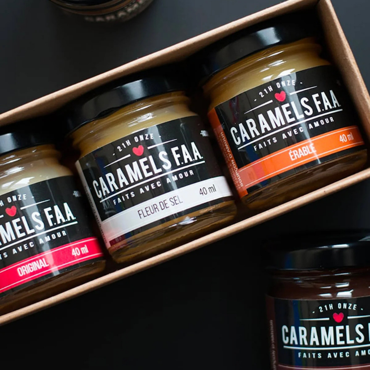 Un coffret contenant 4 pots sur lesquels il est écrit Caramels FAA et des saveur avec un arrière plan noir.