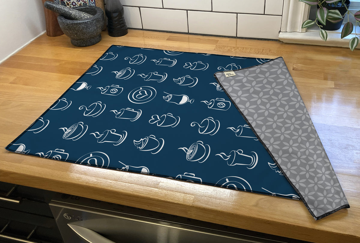 Linge à vaisselle à motifs de tasses à café sur fond bleu marin sur un comptoir de cuisine en bois