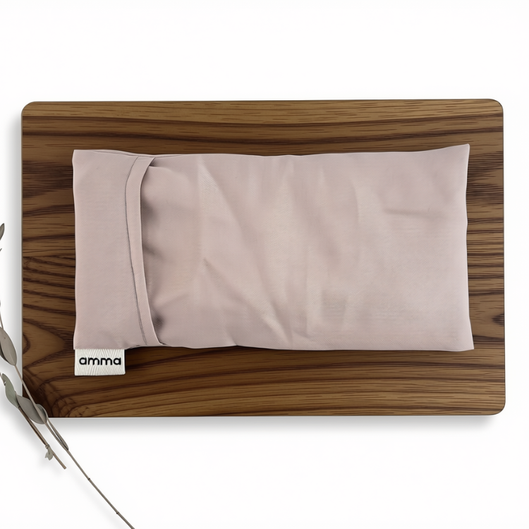 Pochette représentant un masque de relaxation rectangulaire de couleur rose pâle sur une planche en bois sur laquelle il est aussi déposé quelques branches d