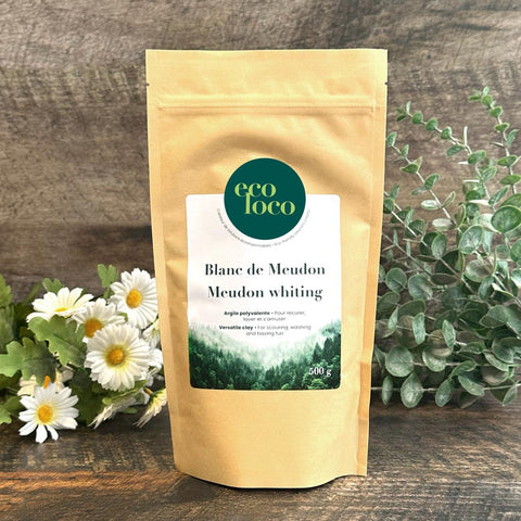 Pochette en papier kraft Eco Loco de Blanc de Meudon sur un fond de bois foncé blanches avec des feuilles vertes et des marguerites blanches