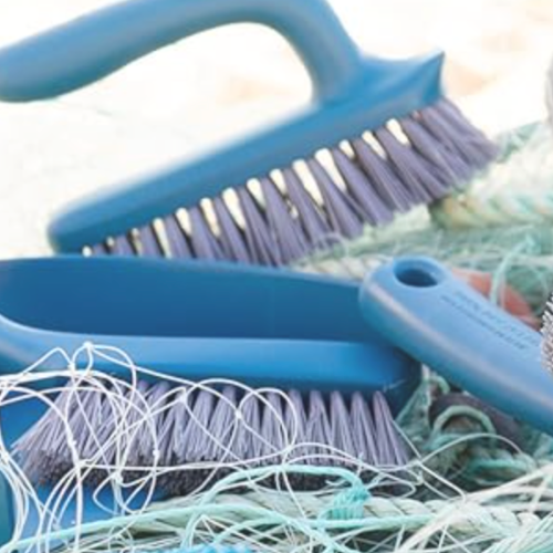 Photo de différentes brosses déposées sur des filets de pêche récupérés.