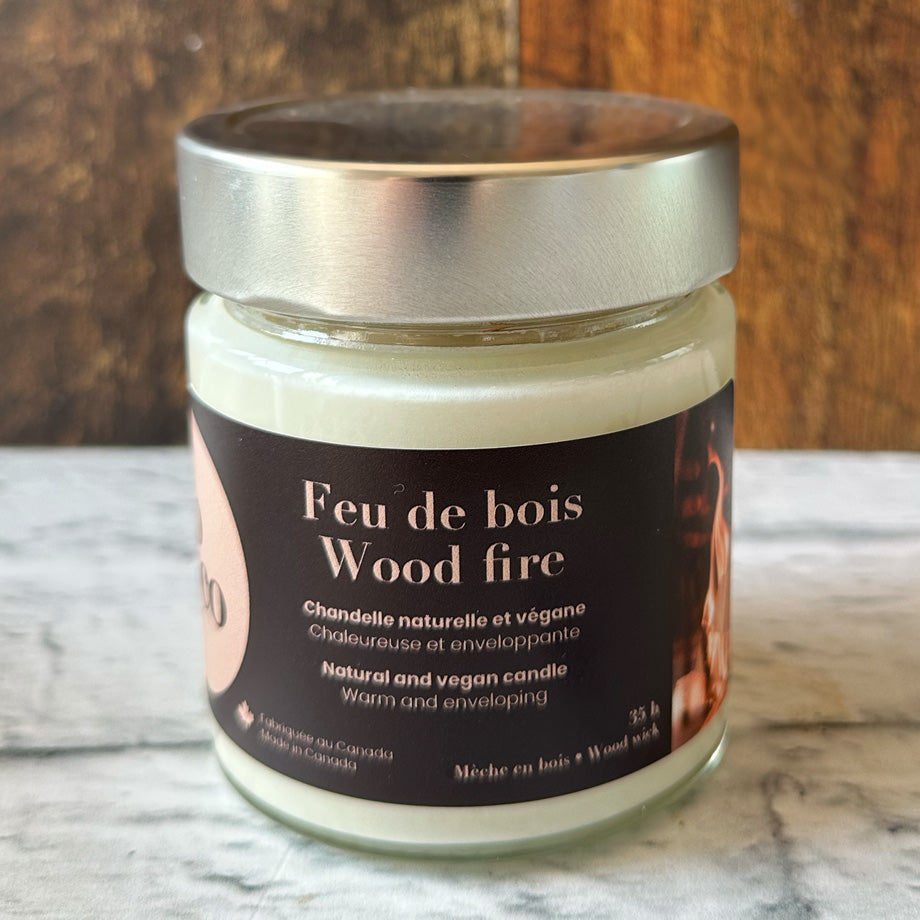 Chandelle naturelle et végane 35 heures sur un comptoir blanc avec un fond de bois fabriquée par Eco Loco de senteur Feu de bois