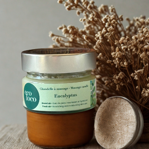 Chandelle à massage Eco Loco à l’eucalyptus, soin nourrissant et hydratant, posée devant un bouquet de fleurs séchées.