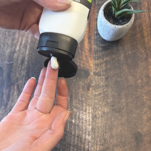 Dentifrice au Xylitol naturel qui sort du pot sur un doigt.