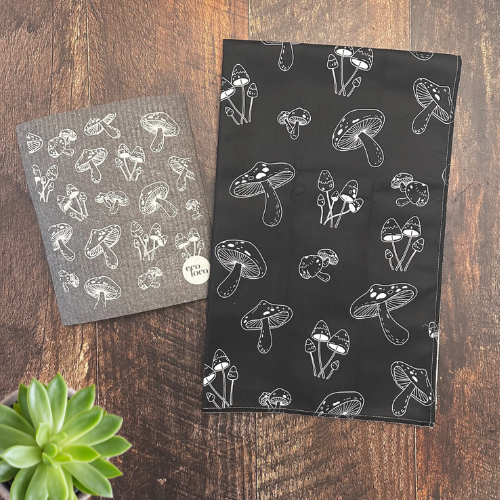 Un chiffon suédois qui remplace les essuie-tout avec un linge vaisselle en microfibre aux motifs de champignon sur une planche en bois