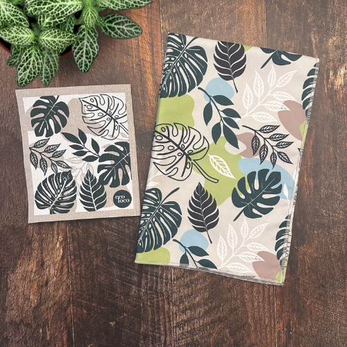 Duo de linge à vaisselle en microfibre et de chiffon suédois avec des motifs de feuilles tropicales sur une planche de bois.
