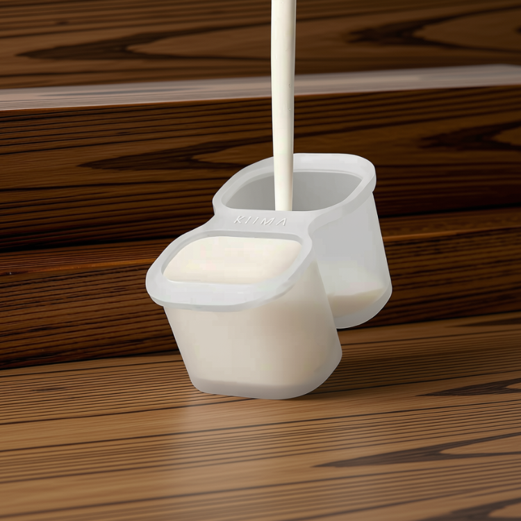 Moule en silicone blanc sur lequel on peut lire KIIMA et dans lequel un liquide blanc épais coule avec un fond de bois.