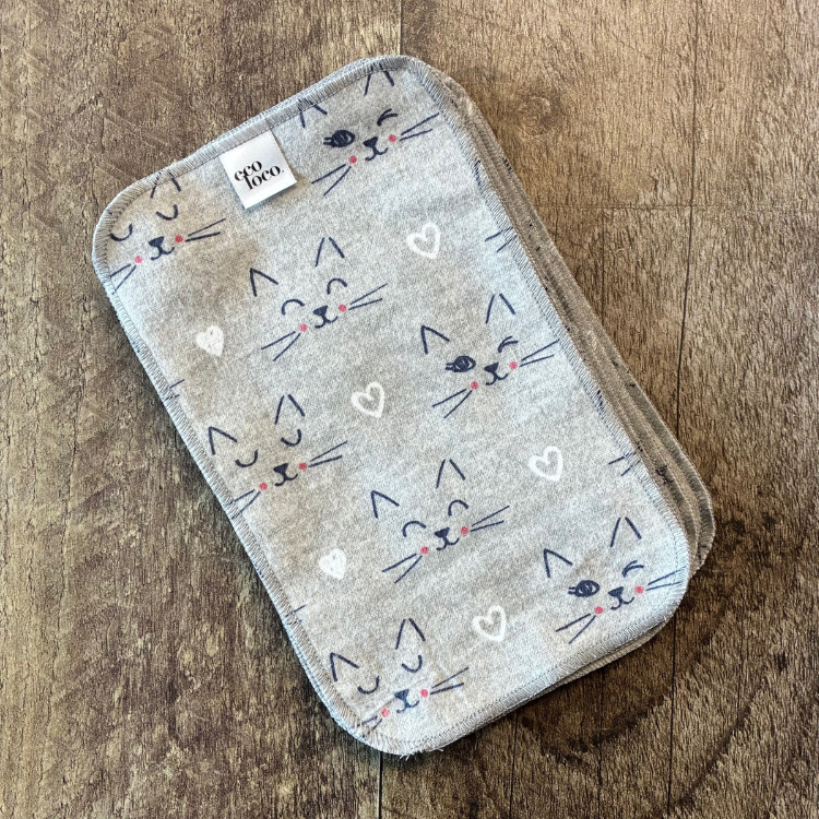 Papier de toilette lavable gris avec des motifs de chat déposé sur une planche de bois