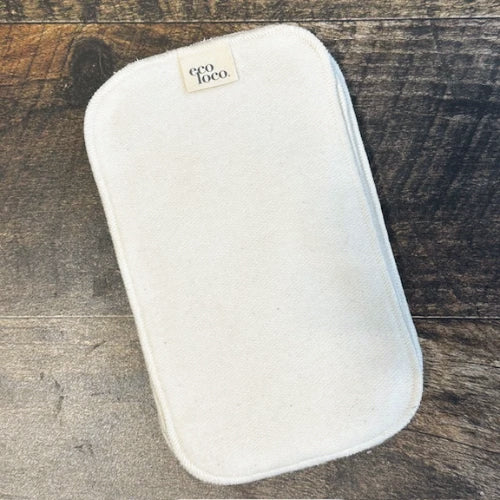 Papier de toilette rectangulaire lavable beige en coton biologique avec une étiquette Eco Loco sur un fond de couleur bois foncé