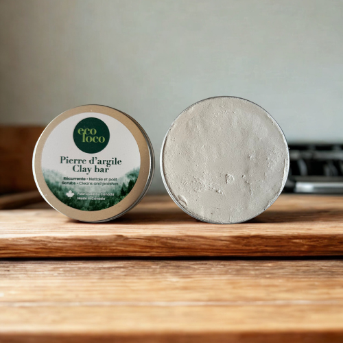 Boîte métallique de pierre d’argile Eco Loco, ouverte en deux, nettoyante et polissante, posée sur un comptoir de cuisine en bois.