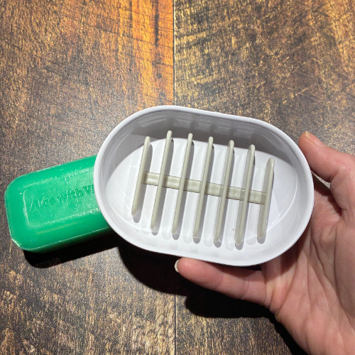 Porte savon à drainage rapide tenu dans une main