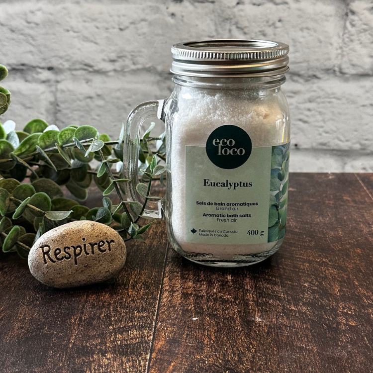 Un sel de bain à l'eucalyptus dans un pot Mason avec poignée et une roche avec l'écriture respirer