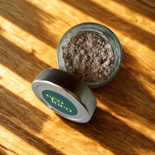 Pot de shampoing sec Eco Loco aux huiles essentielles de lavande, néroli, jasmin, magnolia et ylang-ylang, éclairé par la lumière naturelle sur un comptoir de bois avec beaucoup de lumière.