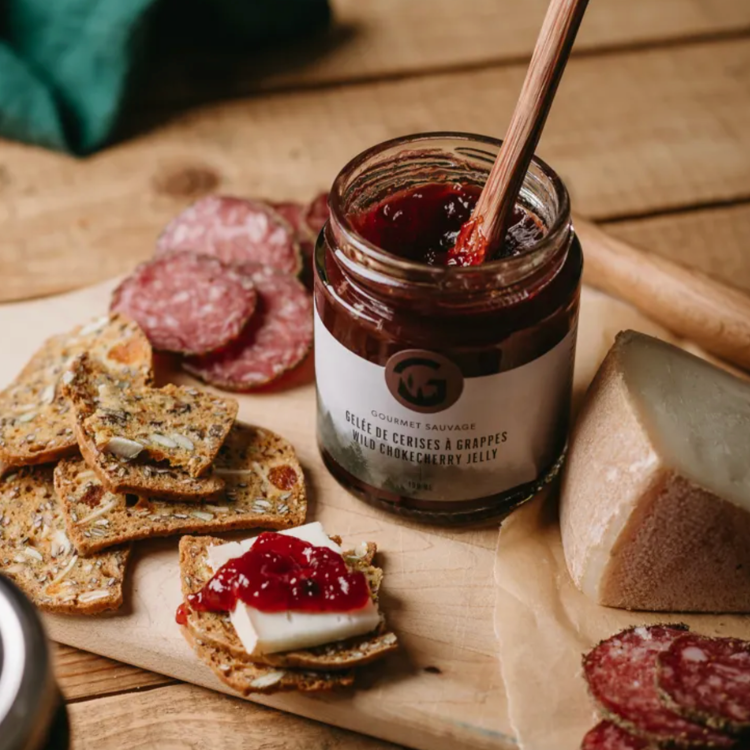 Pot de cerises à grappes cueillies dans la forêt nordique par Gourmet sauvage sur un plateau de fromage et de charcuteries.