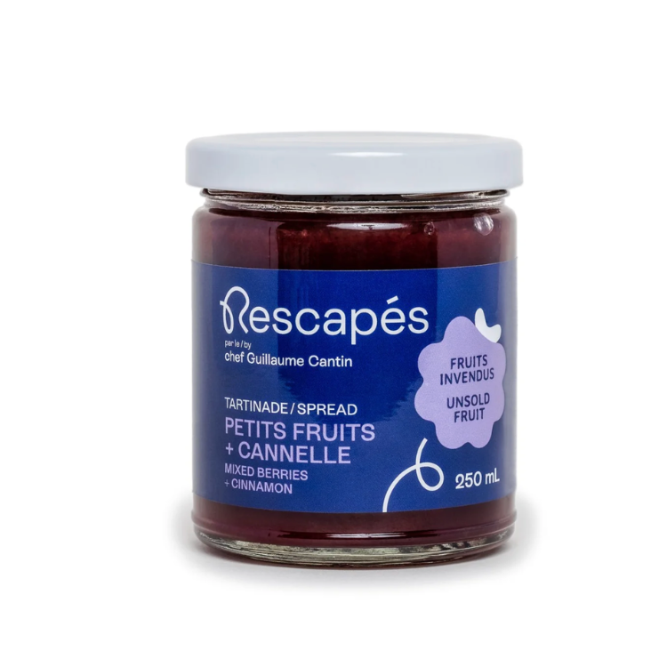 Pot en verre contenant une tartinade de petits fruits et à la cannelle.zéro déchet à partir de fruits rescapés dans les épicerie avec une étiquette bleu et un fond blanc
