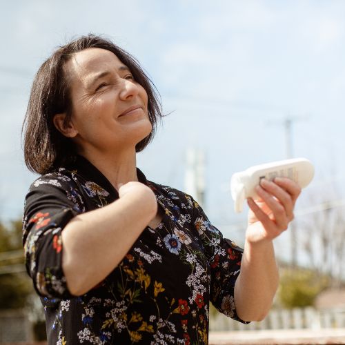 femme qui se met de la crème solaire