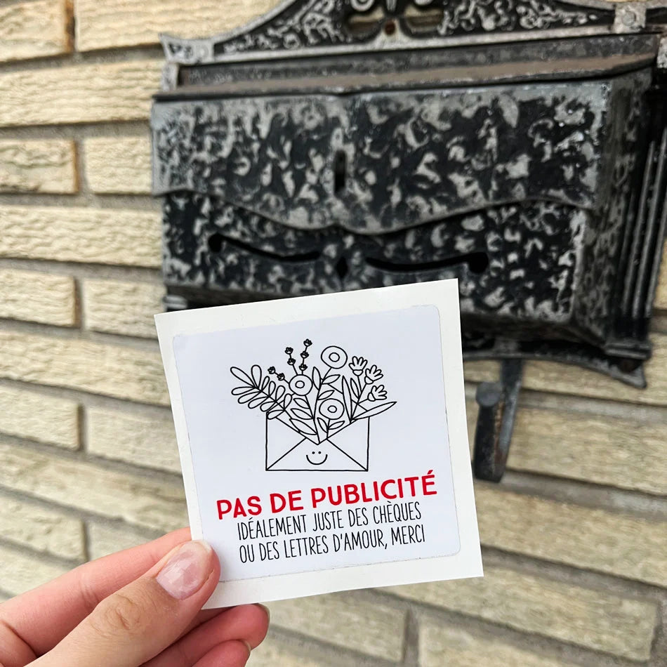 Une main qui tien un autocollant Pas de publicité idéalement juste des chèques ou des lettres d'amour, merci devant une boite à lettres.