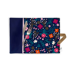Napperon en tissu avec un motif de fleurs marines roses oranges avec une pochette pour ustensiles où en sortent un couteau et une fourchette sur fond blanc