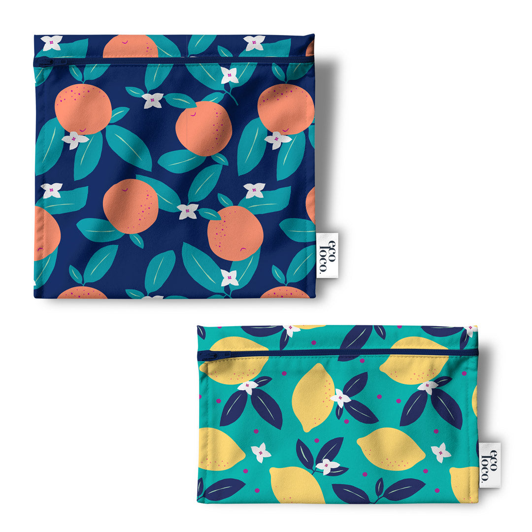 Deux sacs multiusage et à lunch  avec des fermetures Eclair agencé avec des motifs d'agrumes sur un fond blanc et une étiquette de Eco Loco. 