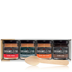 Un coffret blanc contenant 4 pots sur lesquels il est écrit Caramels FAA et des saveur avec une cuillère en bois avec un arrière plan blanc. 