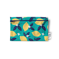 Un sac réutilisable en tissu pour les collations, noix, biscuits, crudités, de couleur turquoise avec des citrons jaunes, des feuilles marine et des petites fleures blanches. Le sac est à plat sur un fond blanc.