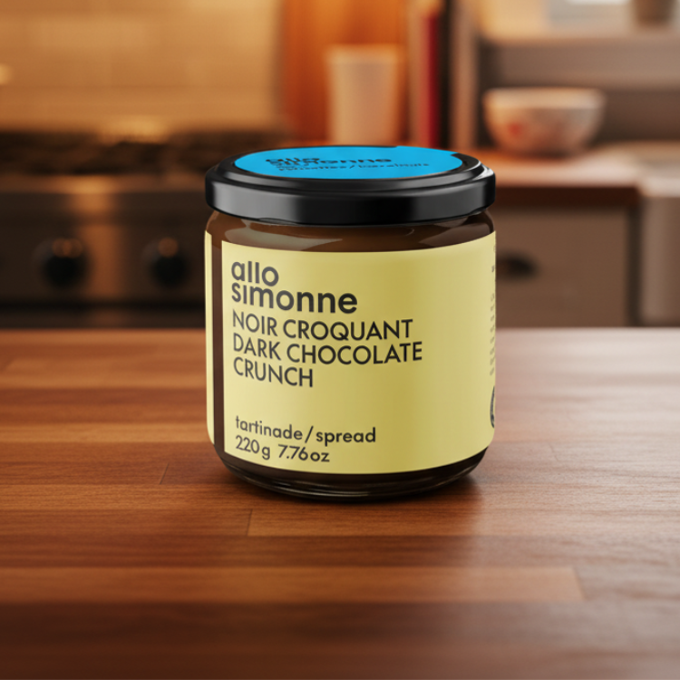 Pot de tartinade au chocolat noir avec une étiquette jaune de la marque québécoise Allo Simonne déposé sur un comptoir en bois dans une cuisine chaleureuse. 