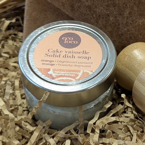 Petit cake à vaisselle à l'orange dans un panier en osier avec un tampon à récurer recyclé. 