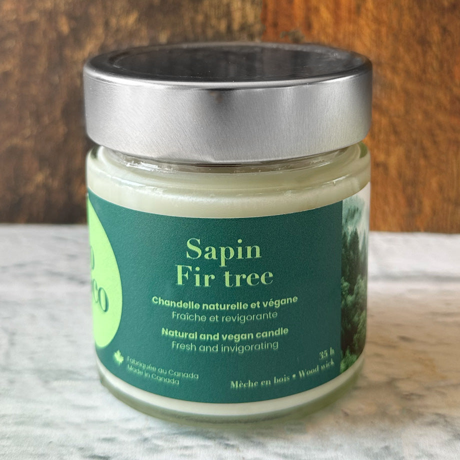 Chandelle naturelle et végane 35 heures sur un comptoir blanc avec un fond de bois fabriquée par Eco Loco de senteur Sapin 
