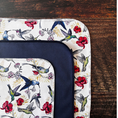Couvre-plat au motif de colibris avec des fleurs sur un bol et une table de bois foncée