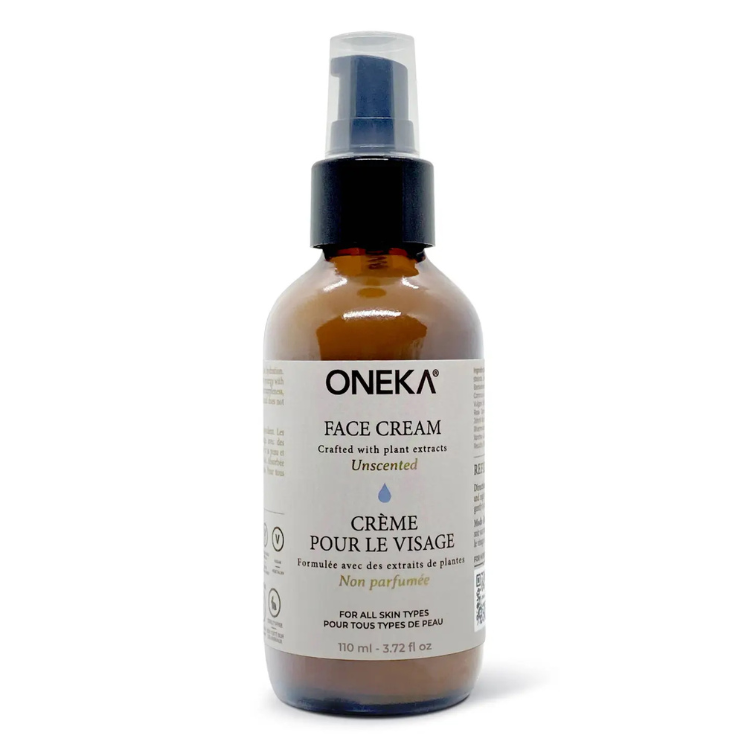 Pot en verre ambré avec une pompe noire sur lequel on peut lire Oneka Crème pour le visage non parfumé en français et en anglais sur un fond blanc