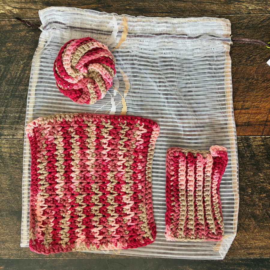 Ensemble de lavettes rouges sur un sac à légumes étendu sur une planche de bois. 