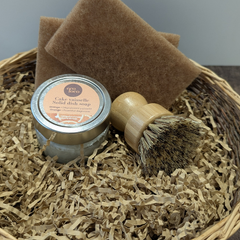 ENsemble pour une vaisselle zéro déchet comprenant une brosse à récurer en bois, un cake vaisselle à l'orange et deux tampons à récurer fait en matière recyclée présentés dans un panier. 