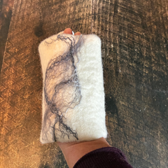 Gant exfoliant en laine feutrée tenu dans une main