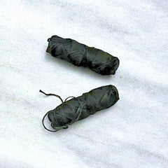 Deux bobines de fil soie dentaire noire compostable et végan sur un fond blanc marbre