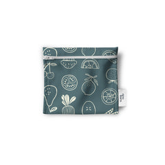 Un sac réutilisable en tissu pour les collations, noix, biscuits, crudités, de couleur bleu gris avec des citrons, tomates, cerises et pommes de couleur blanche. Le sac est à plat sur un fond blanc.