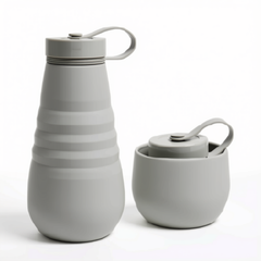 Une image montrant une gourde en silicone rétractable grise pâle dans son format allongé et son format rétracté sur fond blanc. 