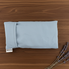 Pochette représentant un masque de relaxation rectangulaire de couleur menthe sur une planche en bois sur laquelle il est aussi déposé quelques branches de lavande séchée. 