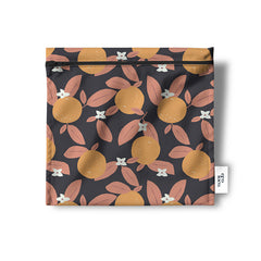 Un sac réutilisable en tissu pour les collations, sandwich, noix, biscuits, crudités, de couleur foncée, presque noire, avec des oranges et des feuilles couleur saumon et de petites fleures blanches. Le sac est à plat sur un fond blanc et porte l'étiquette de Eco Loco