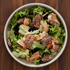 Démonstration d'un bol de salade dans lequel nous voyons de délicieuse pacanes à l'érable déposé sur une planche en bois. 