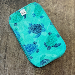 Papier de toilette turquoise avec motif de tortue et l'étiquette Eco Loco sur une planche de bois