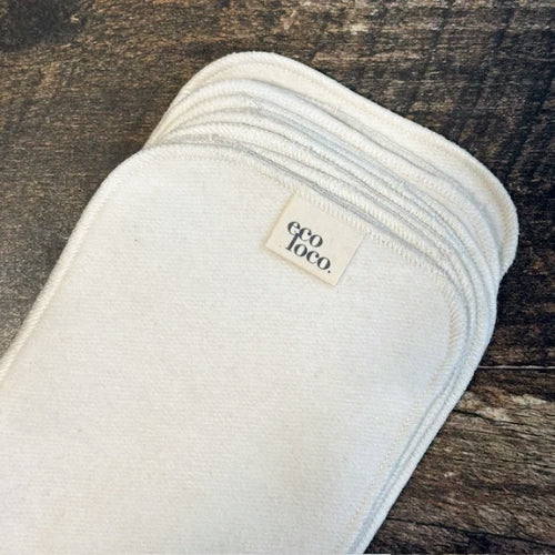 Papier de toilette rectangulaire lavable beige en coton biologique avec une étiquette Eco Loco sur un fond de couleur bois foncé