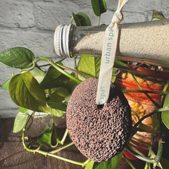 Pierre ponce brune naturelle suspendu sur une bouteille de sable. 