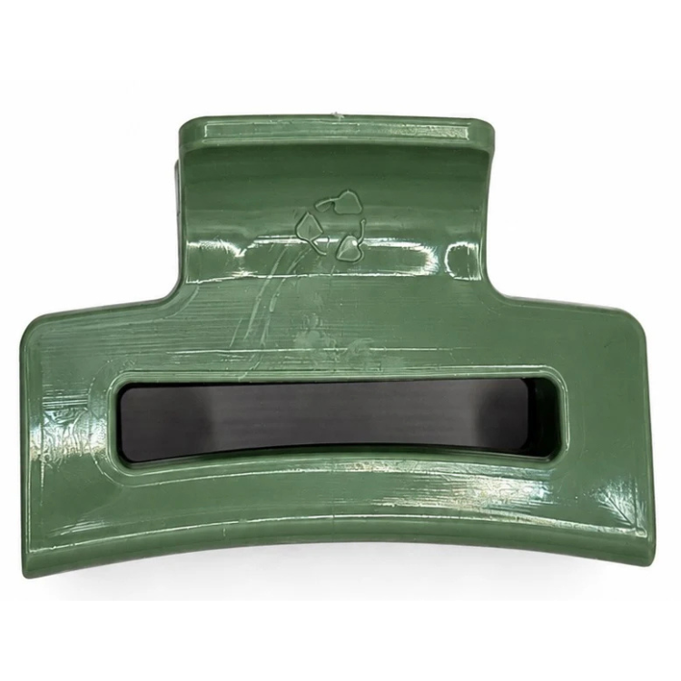 Pince à cheveux verte de Unique plastique avec le logo de recyclage puisqu'entièrement faite de plastique recyclé sur fond blanc. 