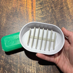 Porte savon à drainage rapide tenu dans une main