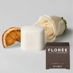 Une tranche d'orange déshudratée, une rose et  recharge de déodorant arrondi et blanche et sa boite brune ou on peut Florèe Kiima