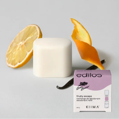 Une tranche ou un zest d'orange ainsi qu'une gousse de vanille et recharge de déodorant arrondi et blanche et sa boite blanche et rose ou on peut lire Kiima et Green Beaver fruity escape recharge de déodorant. 