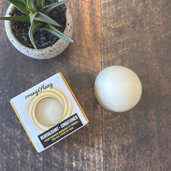 Boite de revitalisant en barre et revitalisant en pain présenté sur une planche de bois et une plante. 