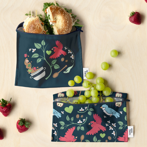 Duo de sacs réutilisables à lunch et collation Eco Loco x Ékip Jeunesse, illustrés par l'artiste québécoise Lily Larochelle, sur fond de fraises et raisins frais