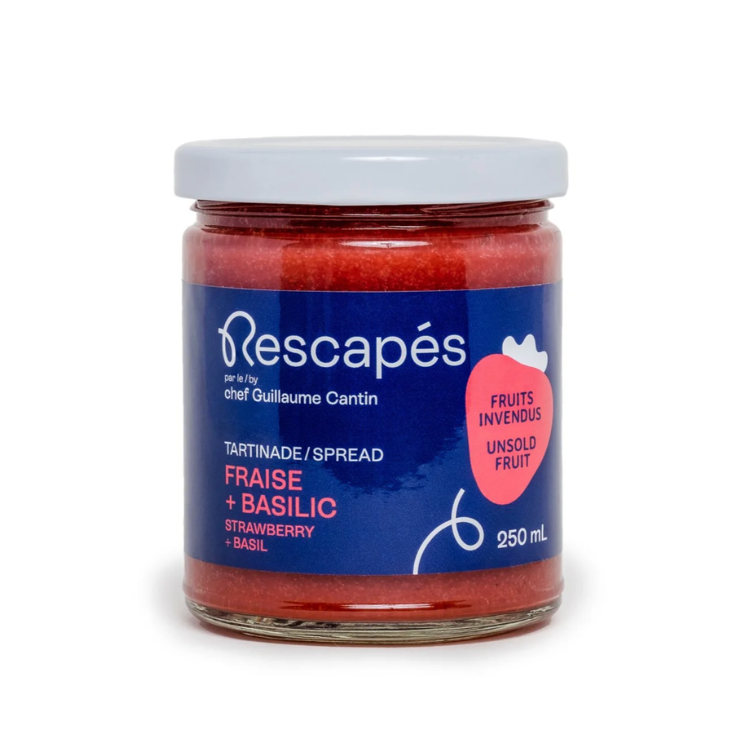 Pot en verre contenant une tartinade à la fraise et au basilic zéro déchet à partir de fruits rescapés dans les épicerie avec une étiquette bleu et un fond blanc